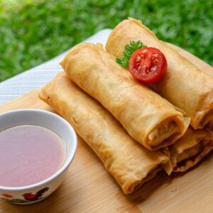 Crispy spring rolls served on a tray with dipping sauce, perfect for a fresh outdoor meal.