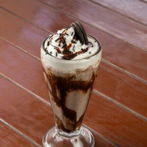 Indulge in a creamy chocolate milkshake topped with whipped cream and an Oreo.