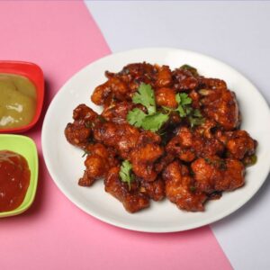 Tasty crispy cauliflower dish with two savory sauces on a vibrant background.
